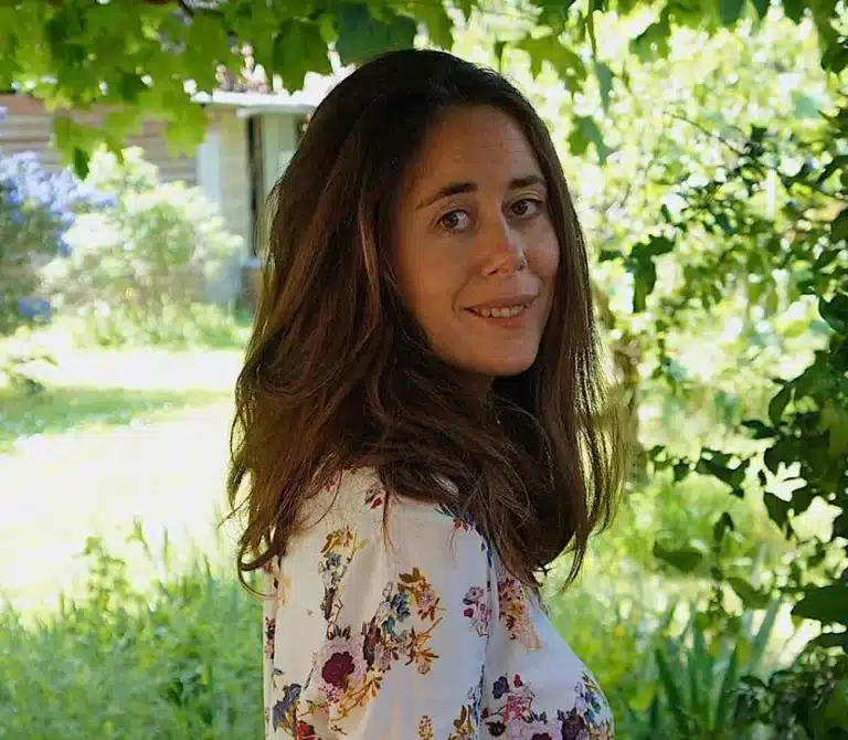 Juliette, propriétaire d'une maison d'hôtes bien-être, posant dans son jardin